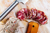 Traditional Italian dry cured pork sausage Salame piacentino with sliced pieces on wooden background