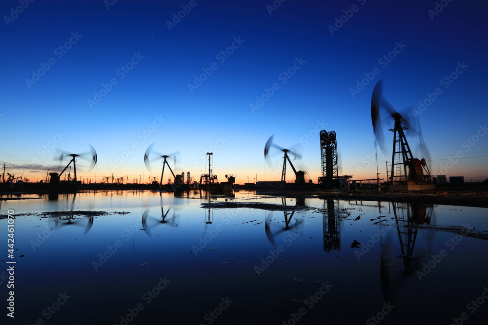 In the evening, oil pumps are running, Silhouette of beam pumping unit In the evening, oil pumps are running, Silhouette of beam pumping unit