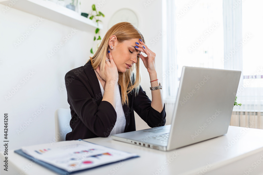 Young frustrated woman working at office desk in front of laptop suffering from chronic daily headaches, treatment online, appointing to a medical consultation, electromagnetic radiation, sick pay Young frustrated woman working at office desk in front of laptop suffering from chronic daily headaches, treatment online, appointing to a medical consultation, electromagnetic radiation, sick pay