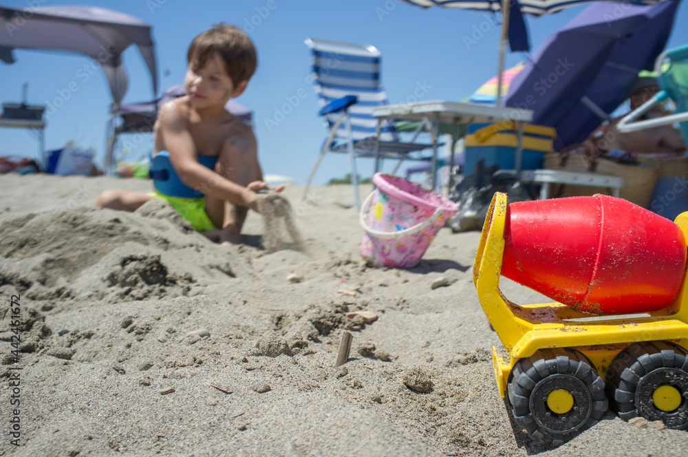 Little boy playing with sand and beach toys Little boy playing with sand and beach toys