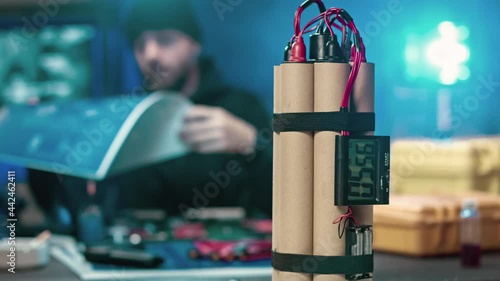 A terrorist out of focus camera is studying the scheme. In the foreground a bomb photo