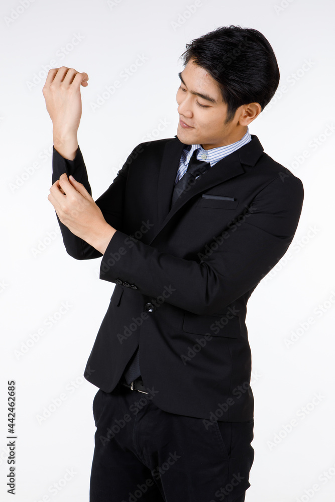 Portrait shot of Asian young healthy black short hair handsome white collar office worker in formal suit standing smiling adjusting button on sleeve in front of white background Portrait shot of Asian young healthy black short hair handsome white collar office worker in formal suit standing smiling adjusting button on sleeve in front of white background
