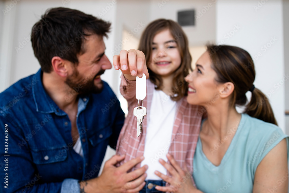 Portrait of smiling caucasian family with daughter holding keys of their new home. Portrait of smiling caucasian family with daughter holding keys of their new home.