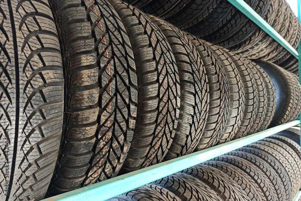 Many black rubber car tires on store shelf for sale. Many black rubber car tires on store shelf for sale.