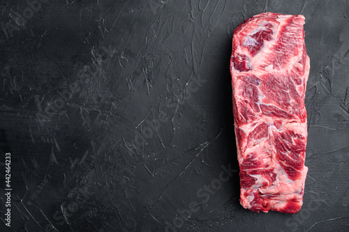 Scotch Fillet whole cut, marbled beef rib eye top choice meat, on black stone background, top view flat lay, with copy space for text