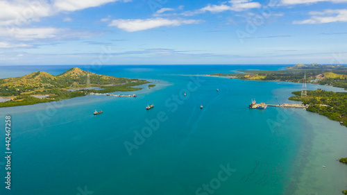 Aerial view of tropical Islands with beaches in the blue sea against the sky and clouds. © Alex Traveler