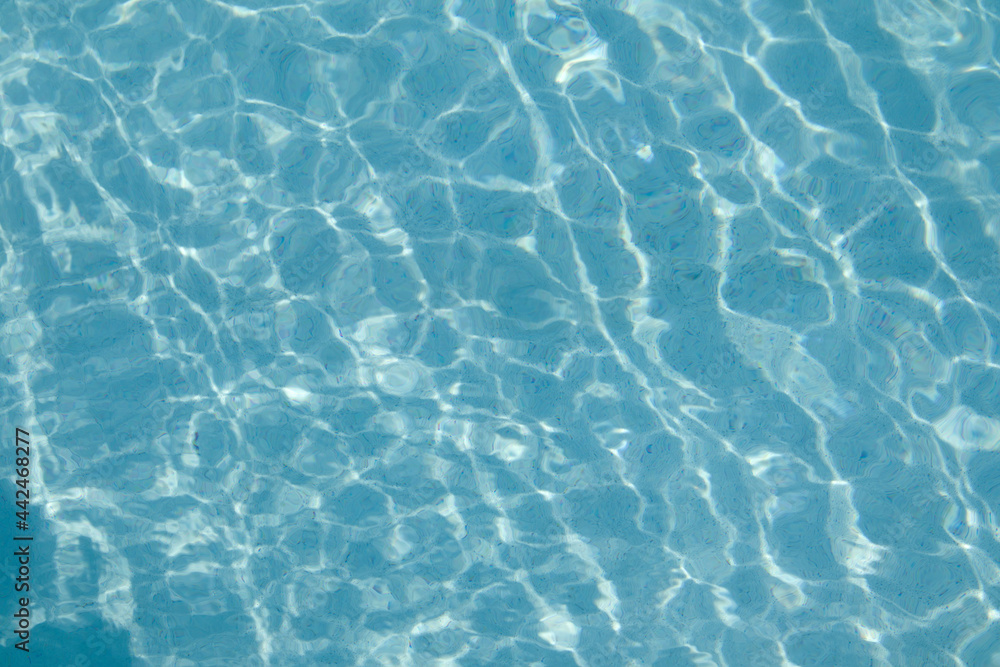 Light blue swimming pool bottom with clear water surface textured background Light blue swimming pool bottom with clear water surface textured background