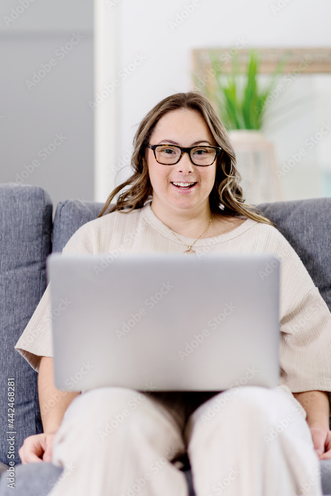 young woman with Down Syndrome using computer at home young woman with Down Syndrome using computer at home