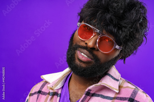 Fashion portrait of african american man in glasses against purple background