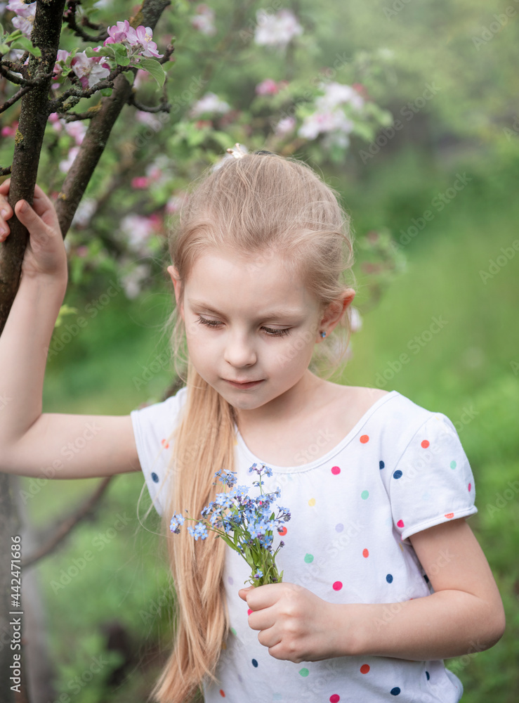 Little girl with blue forget-me-not flowers in her hands Little girl with blue forget-me-not flowers in her hands