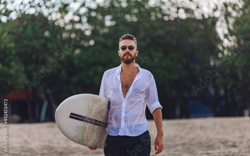 Young man goes to ride the waves with a surfboard.