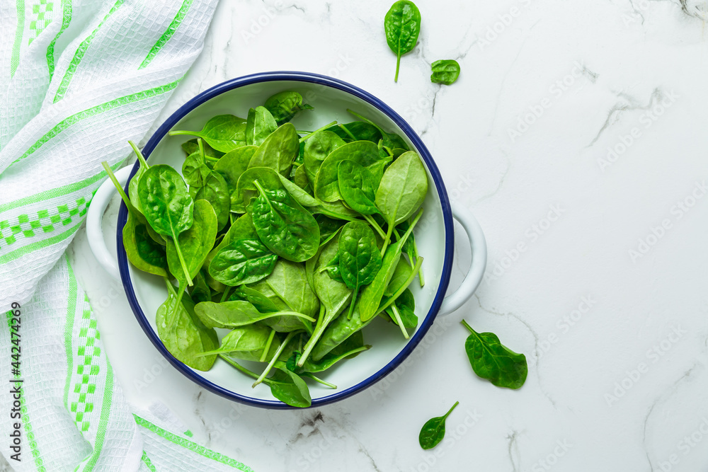 Obraz premium Organic raw spinach in bowl on white background