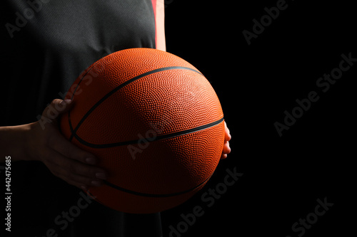 Basketball player with ball on black background, closeup. Space for text