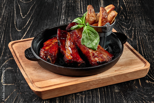 Grilled pork ribs with barbecue sauce and potato wedges