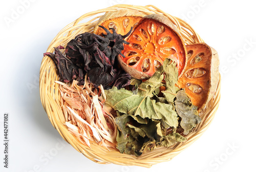 Dried Mulberry Leaves, dried roselle, dried bael fruit and dried lemongrass leaves in basket.