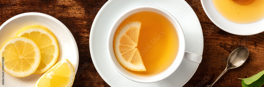 Lemon tea with honey panorama. Healthy and tasty organic citrus detox beverage, shot from the top on a rustic wooden table Lemon tea with honey panorama. Healthy and tasty organic citrus detox beverage, shot from the top on a rustic wooden table