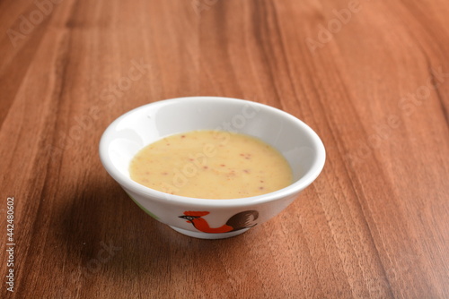 chef hand made cook salted egg yolk paste sauce in traditional cock chicken bowl on wood table asian halal menu