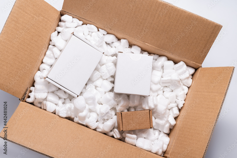 Lot of loose white Filler Shipping Packing Peanuts in cardboard box Stock  Photo | Adobe Stock