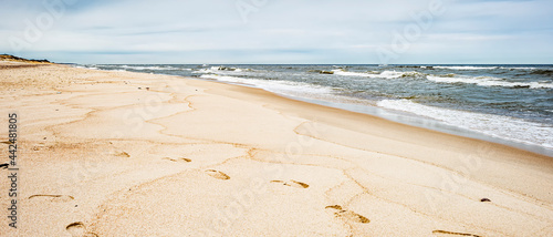 Panel kuchenny z motywem Sea waves and footprints on the sand on the beach and overcast sky