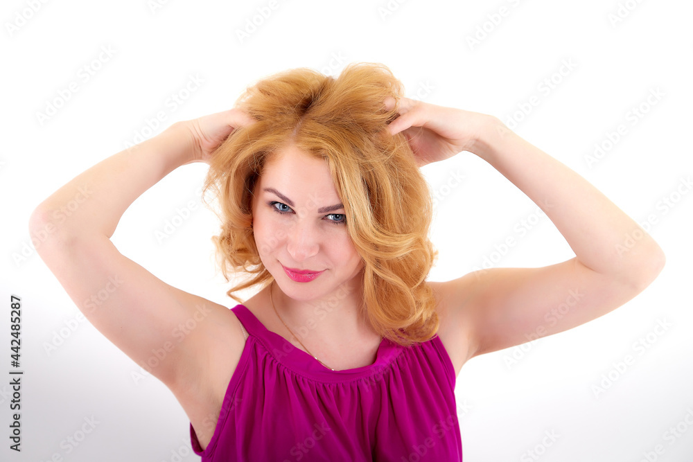 Beautiful female model with blonde long curly hair posing in studio on a white bacground in nice dress Beautiful female model with blonde long curly hair posing in studio on a white bacground in nice dress
