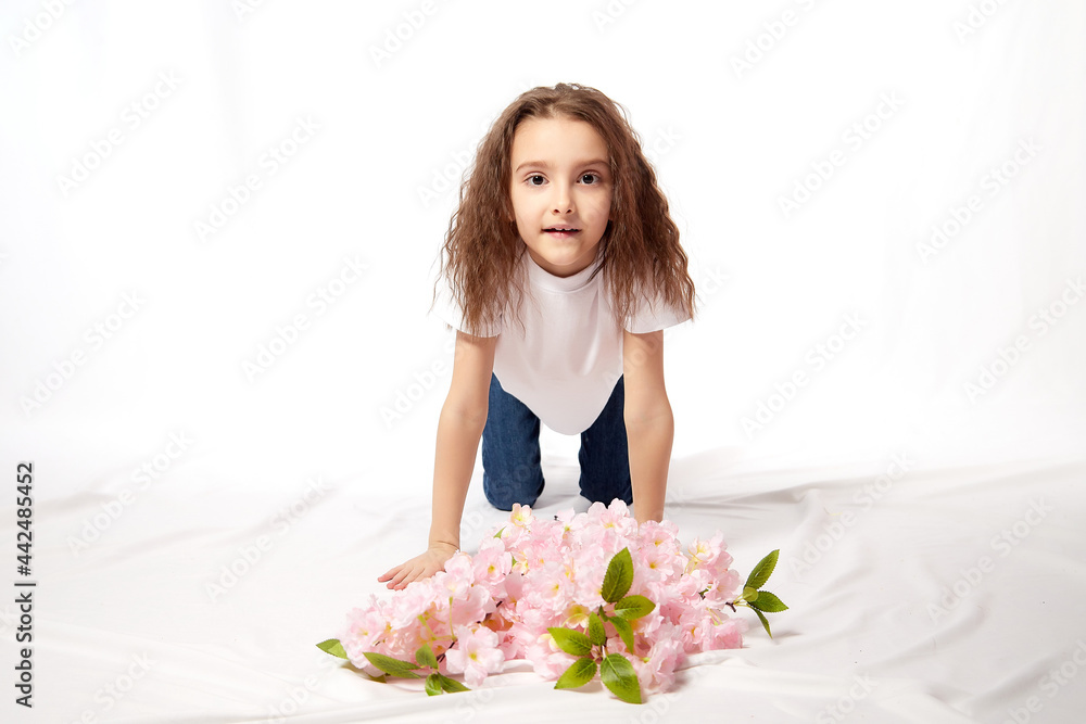 Girl with flowers in the studio on a white background. Teenager posing indoors Girl with flowers in the studio on a white background. Teenager posing indoors