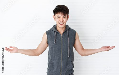 Asian handsome fit smiling man holding hand smartphone taking a selfie.happy gesture wearing sleeveless t-shirt gray sportswear in white background.
