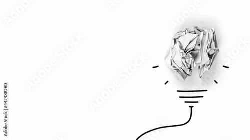 Paper being crumbled into a light bulb on white background. Concept of Innovation and Creativity . High quality 4k video.