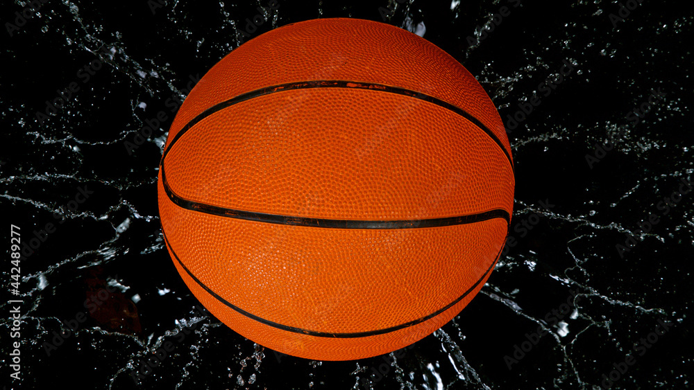 Falling basketball ball on water surface, black background. Top down view. Falling basketball ball on water surface, black background. Top down view.