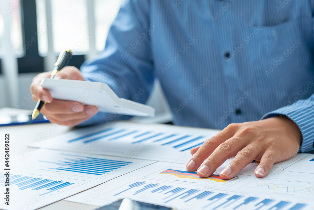 Close up account man hand using calculator for calculate and writing make a note with pen, ..financial reporting and business performance to check investment results Close up account man hand using calculator for calculate and writing make a note with pen, ..financial reporting and business performance to check investment results