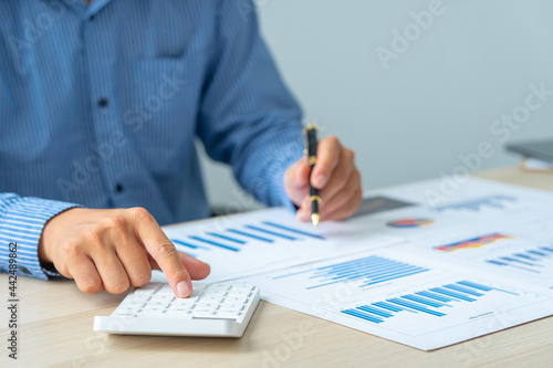 Close up account man hand using calculator for calculate and writing make a note with pen, ..financial reporting and business performance to check investment results