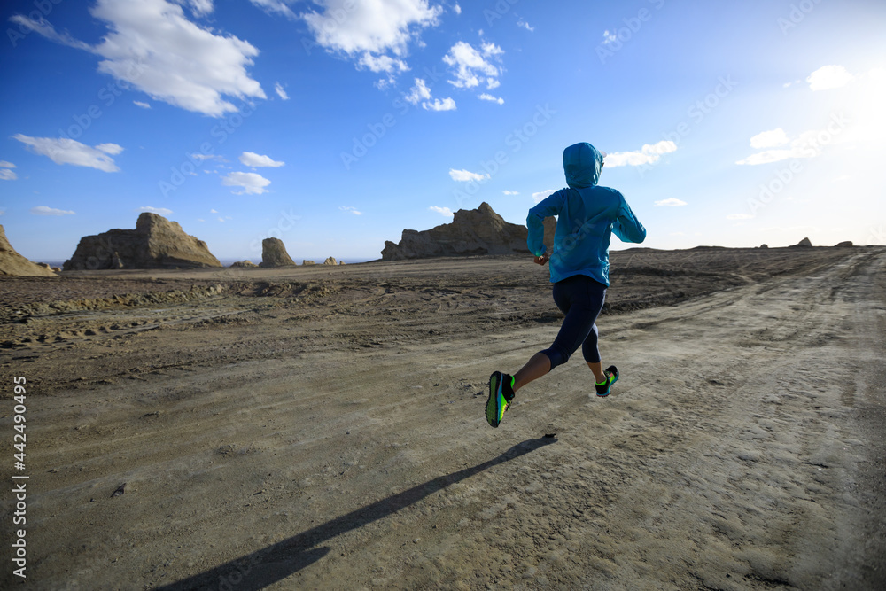 Fitness woman trail runner cross country running  on sand desert