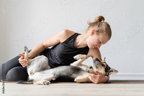 Young sportive woman embracing her mixed breed dog