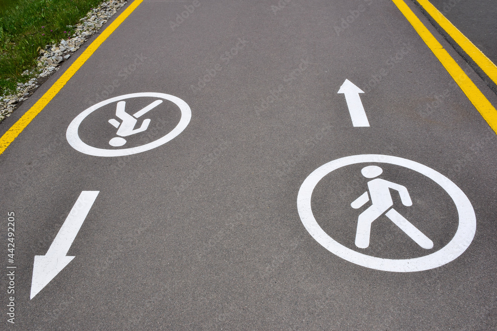 On the asphalt road there are signs for pedestrians in both directions, allowing movement for walking On the asphalt road there are signs for pedestrians in both directions, allowing movement for walking