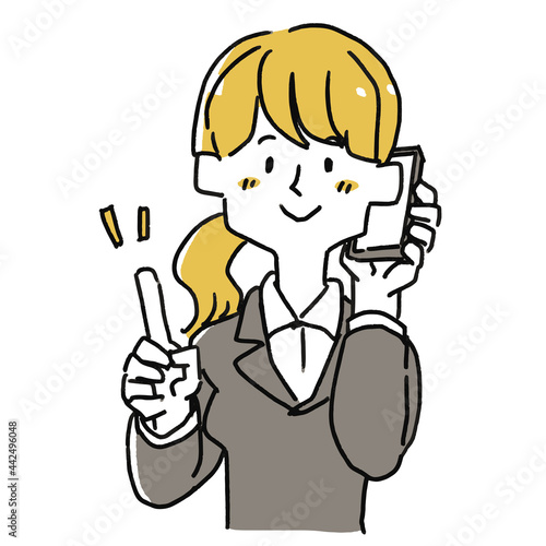 携帯電話で話をしているスーツの女性