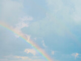 Multicolored rainbow in the cloudy sky. Natural phenomenon after rain