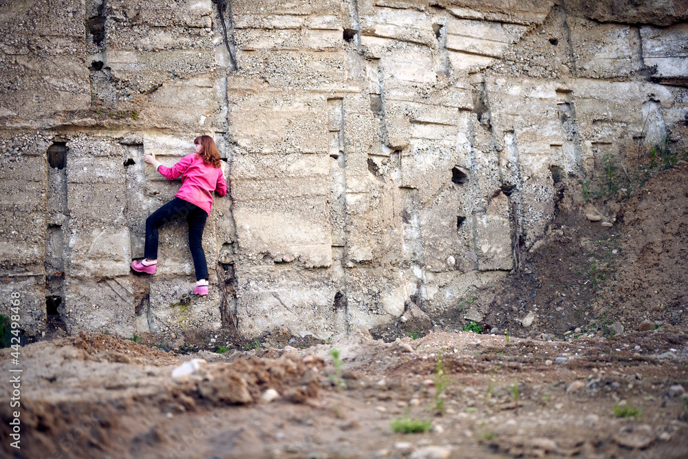 Woman climbs up the concrete wall Woman climbs up the concrete wall