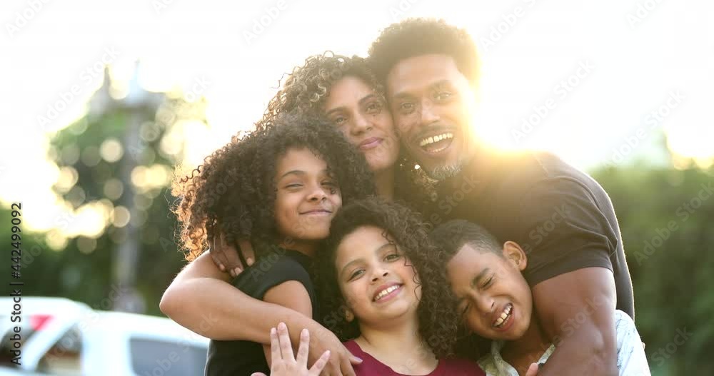 Loving family embrace outside in sunlight with lens-flare, black African ethnicity Loving family embrace outside in sunlight with lens-flare, black African ethnicity