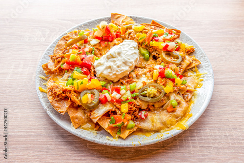 Corn nachos with cream cheese, pulled pork, sliced jelly beans, tricolor peppers and gratin cheddar cheese