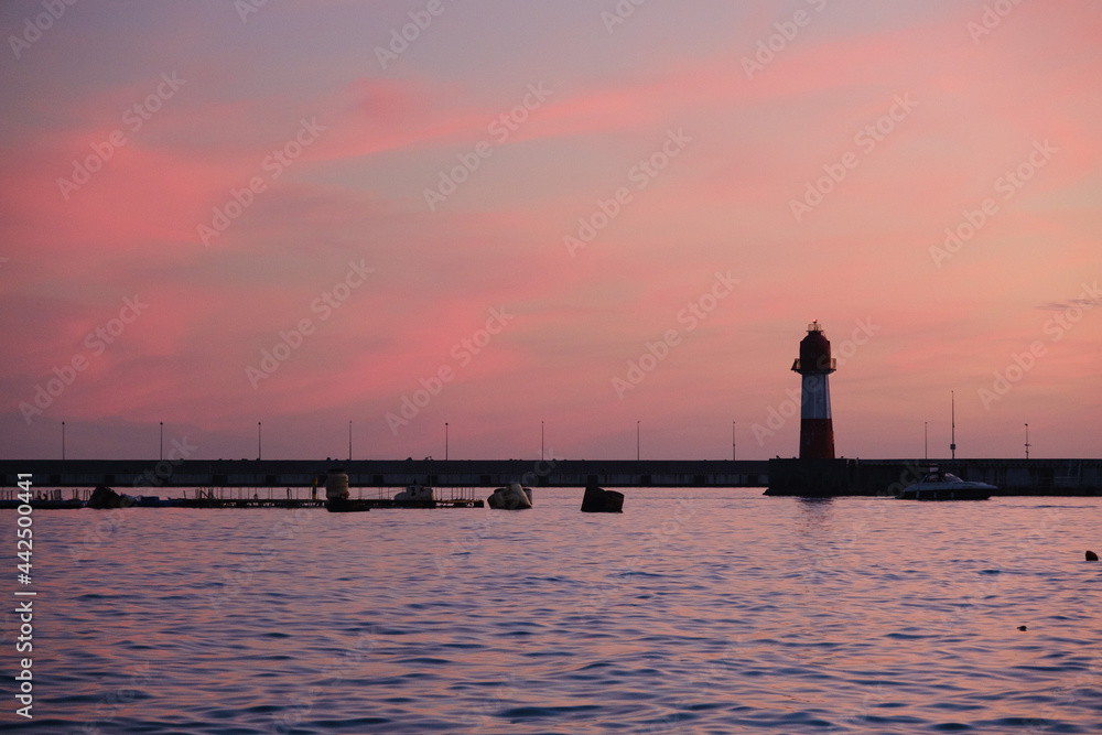 Fototapeta premium sunset over the harbor and lighthouse