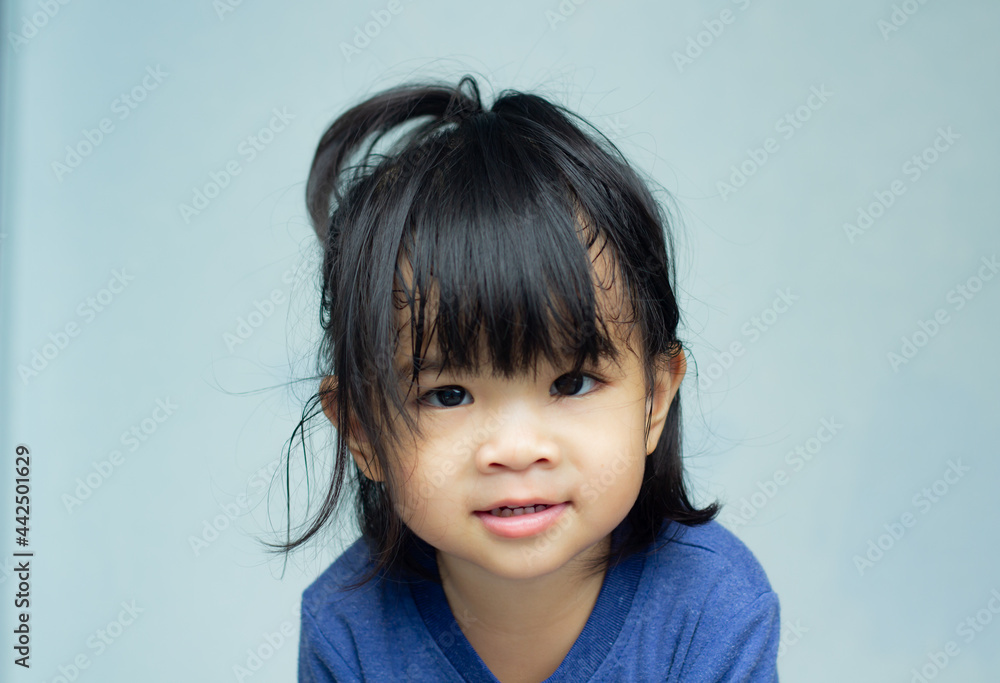 A headshot portrait of a cheerful baby Asian woman, a cute toddler little girl with adorable bangs hair, a child wearing a blue sweater smiling and looking to the camera. A headshot portrait of a cheerful baby Asian woman, a cute toddler little girl with adorable bangs hair, a child wearing a blue sweater smiling and looking to the camera.
