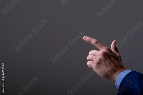 Midsection of caucasian businessman touching virtual interface, isolated on grey background