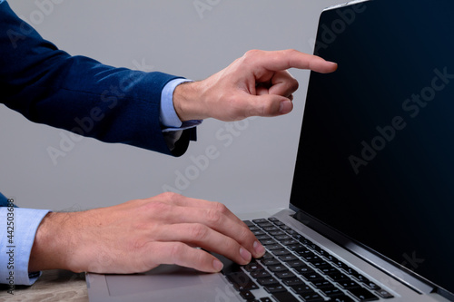 Midsection of caucasian businessman using laptop, isolated on grey background photo