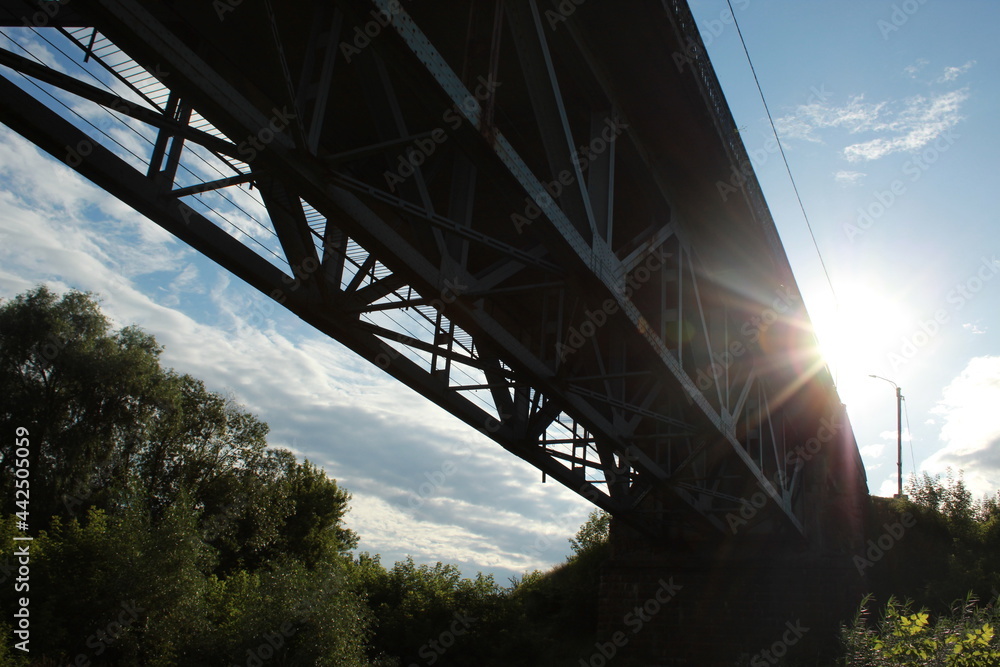 Naklejka premium bridge over the river at sunset