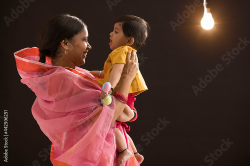 A woman holding and playing with her baby. photo