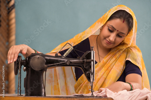 A woman working with a sewing machine. photo