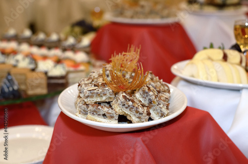 Wallpaper Mural Catering a plate on a red tablecloth with small cakes made of different nuts and peanuts decorated with caramel Torontodigital.ca