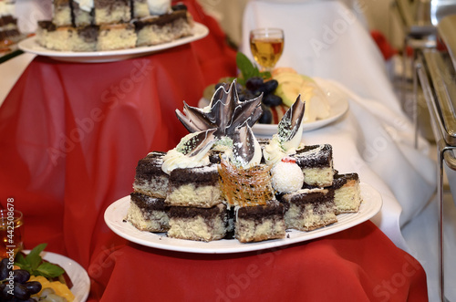 Wallpaper Mural Catering plate on a red tablecloth with small brown and white cakes decorated with both white and dark chocolate Torontodigital.ca