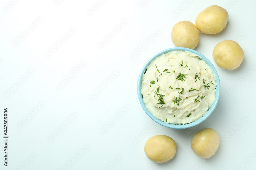 Plate of mashed potatoes and ingredients on white background