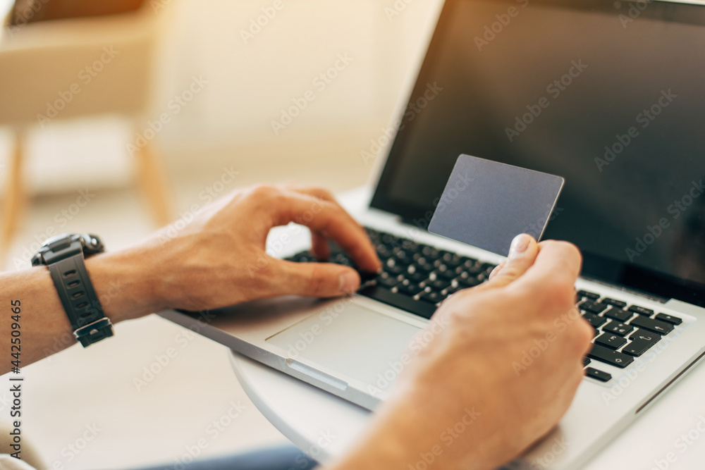 Online payment. Man holding credit card and using laptop, man working on computer, business, finance, online shopping Online payment. Man holding credit card and using laptop, man working on computer, business, finance, online shopping