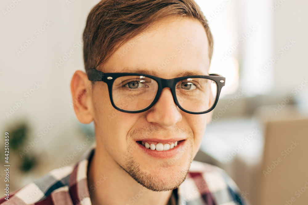 young man wearing glasses and casual plaid shirt, happy man smiling and looking at camera young man wearing glasses and casual plaid shirt, happy man smiling and looking at camera